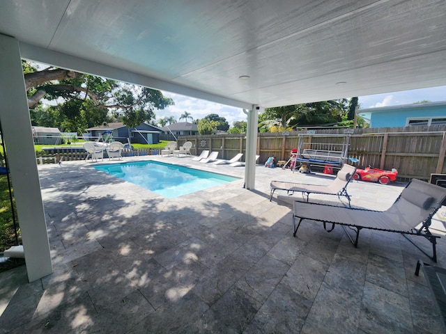 view of pool featuring a patio and a trampoline