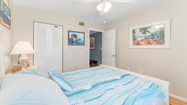 bedroom featuring ceiling fan, hardwood / wood-style floors, a closet, and a textured ceiling