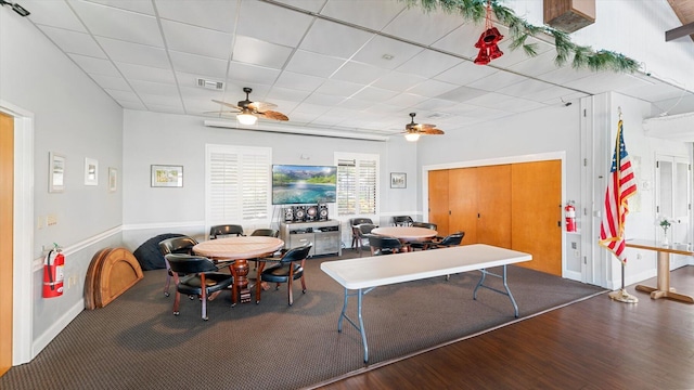 dining room featuring a drop ceiling, hardwood / wood-style floors, and ceiling fan