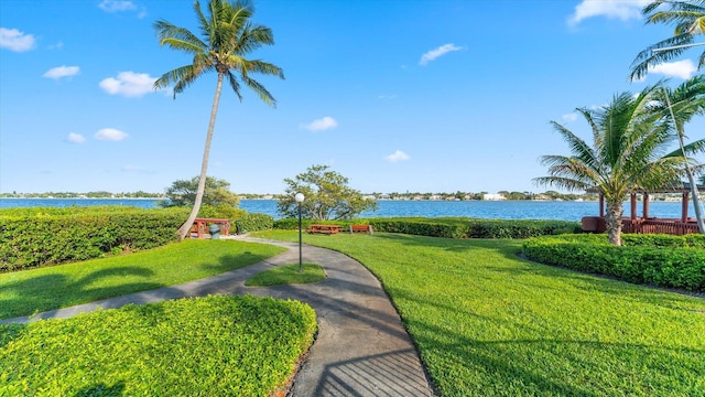 view of home's community with a water view and a lawn