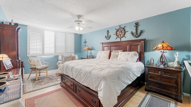 bedroom featuring ceiling fan, a textured ceiling, and light hardwood / wood-style flooring