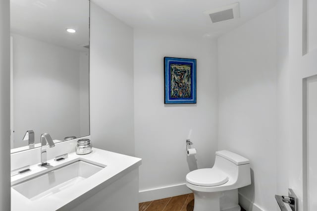 bathroom featuring vanity, hardwood / wood-style floors, and toilet