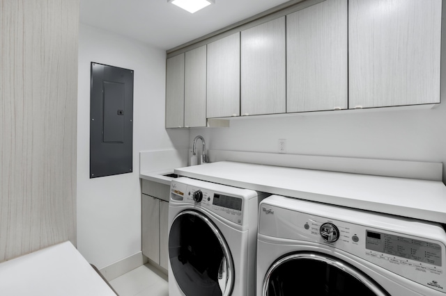 clothes washing area featuring washer and dryer, sink, electric panel, and cabinets