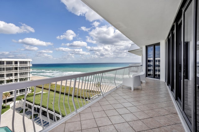 balcony with a water view and a beach view