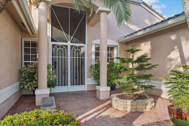 view of exterior entry with a patio area