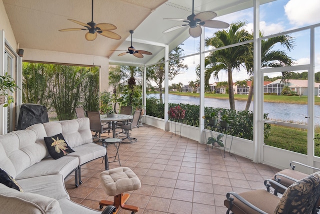 sunroom / solarium with lofted ceiling, ceiling fan, and a water view