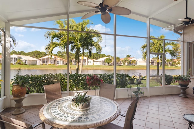 sunroom featuring ceiling fan and a water view