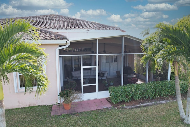 rear view of house featuring a yard and a sunroom