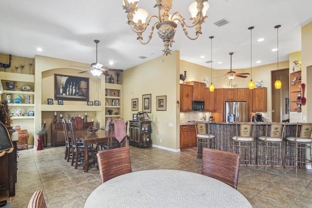 dining room with built in shelves, a towering ceiling, and ceiling fan with notable chandelier