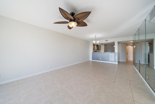 unfurnished living room with ceiling fan with notable chandelier and light tile patterned floors