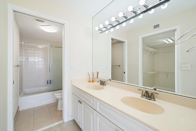 full bathroom with toilet, tile patterned floors, bath / shower combo with glass door, and vanity