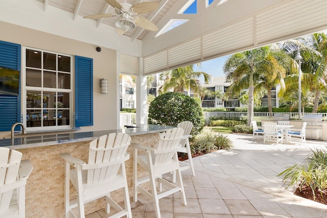 view of patio / terrace with ceiling fan and exterior bar