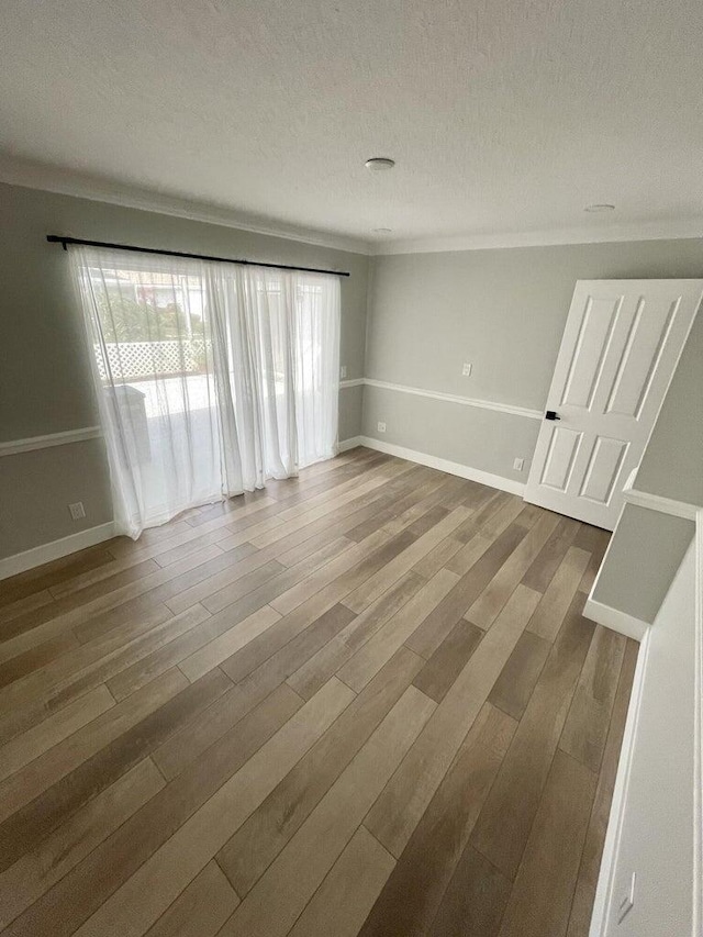 empty room with wood-type flooring and a textured ceiling