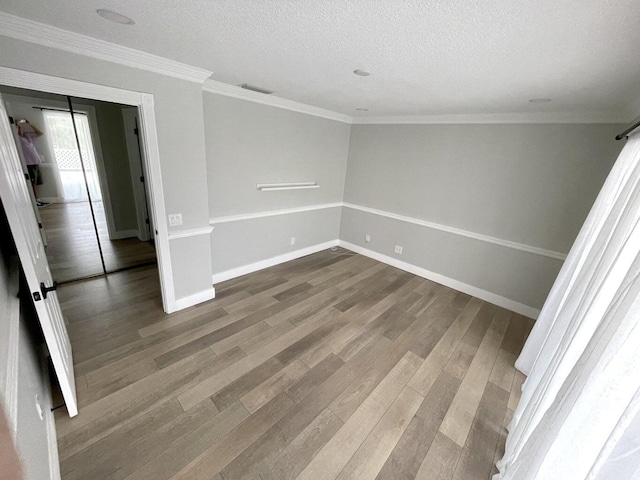 spare room with crown molding, hardwood / wood-style floors, and a textured ceiling