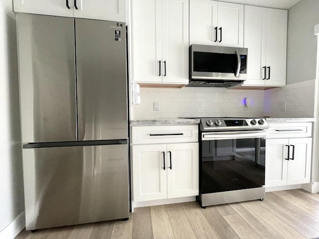 kitchen featuring white cabinetry, appliances with stainless steel finishes, decorative backsplash, and light wood-type flooring