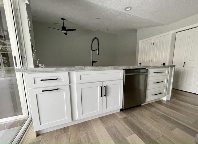 kitchen with sink, light hardwood / wood-style flooring, dishwasher, and white cabinets