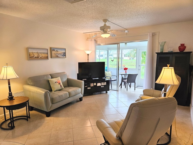 living room with ceiling fan, a textured ceiling, and light tile patterned floors