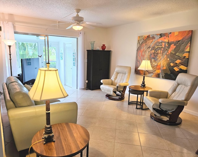 tiled living room with ceiling fan and a textured ceiling