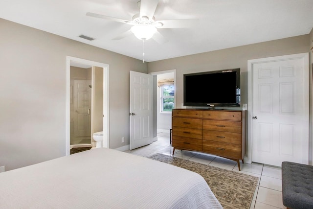 bedroom with ensuite bathroom, ceiling fan, and light tile patterned flooring