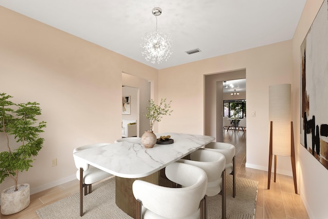 dining space with an inviting chandelier and light hardwood / wood-style floors