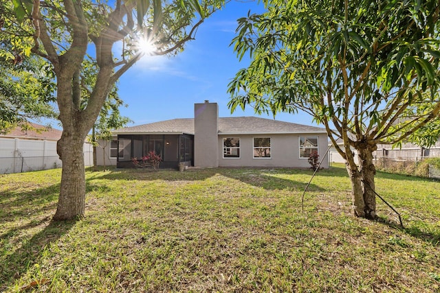 back of house featuring a yard and a sunroom