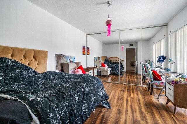 bedroom with dark hardwood / wood-style flooring and a textured ceiling