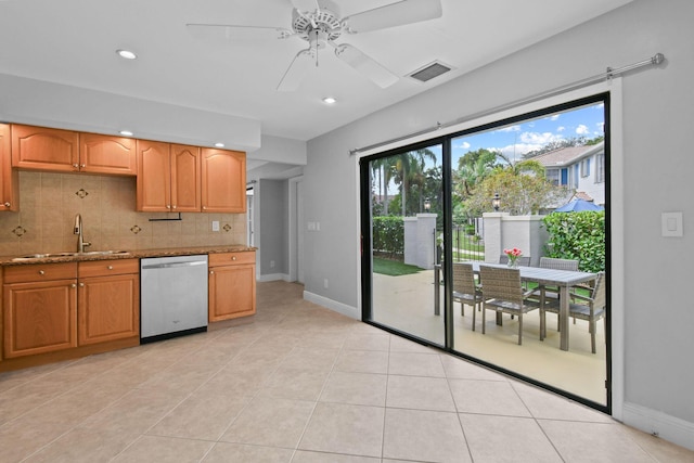 kitchen featuring light tile patterned flooring, sink, stainless steel dishwasher, light stone countertops, and decorative backsplash