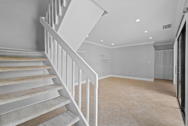 stairs with crown molding and tile patterned floors