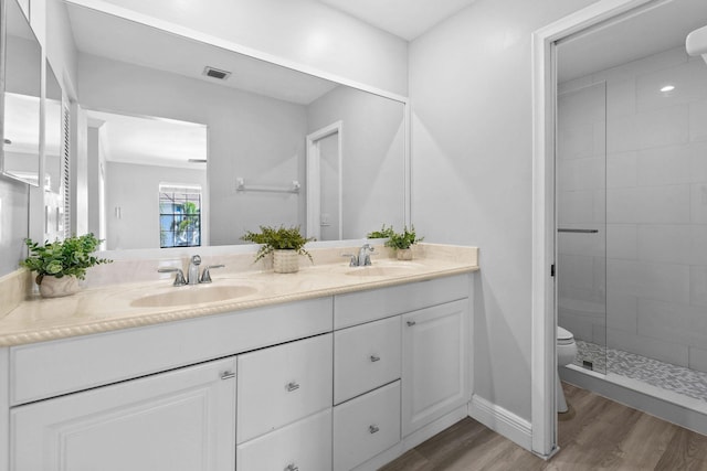 bathroom featuring hardwood / wood-style flooring, vanity, walk in shower, and toilet