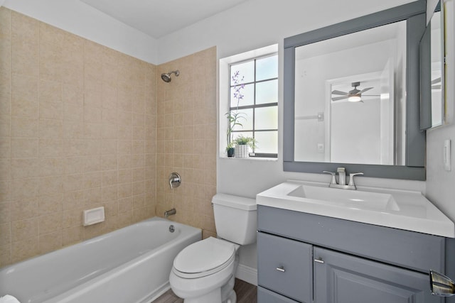 full bathroom with vanity, hardwood / wood-style floors, tiled shower / bath combo, and toilet