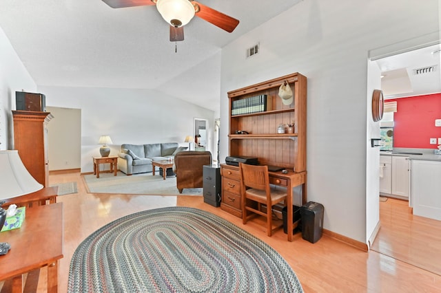 living room with ceiling fan, lofted ceiling, and light wood-type flooring