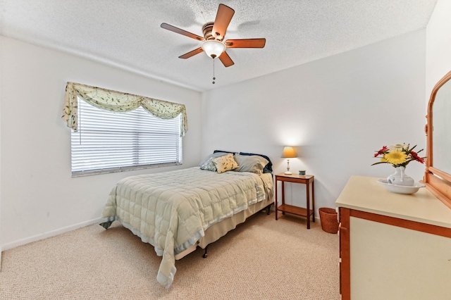 bedroom featuring light carpet, ceiling fan, and a textured ceiling