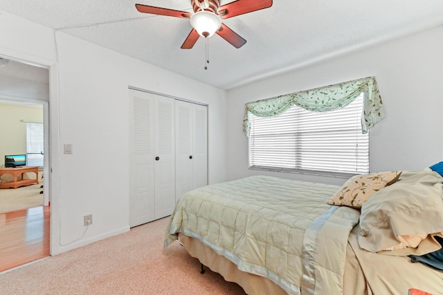 carpeted bedroom featuring a closet and ceiling fan