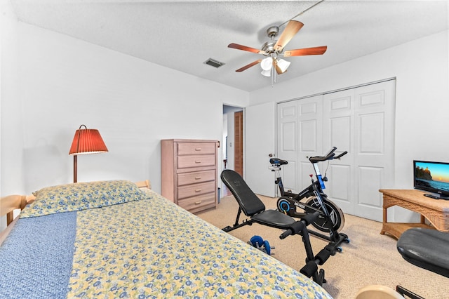 carpeted bedroom featuring a textured ceiling, ceiling fan, and a closet