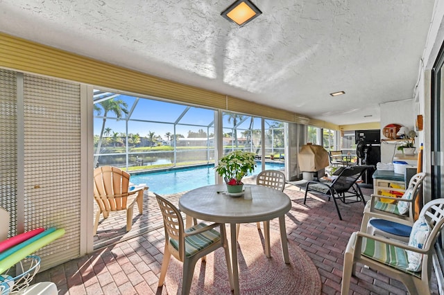 sunroom featuring a water view