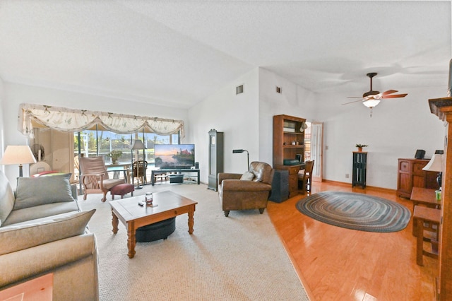 living room with wood-type flooring, lofted ceiling, and ceiling fan