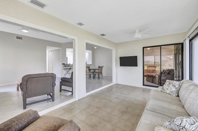 tiled living room with ceiling fan