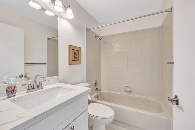 full bathroom featuring tiled shower / bath, vanity, and toilet