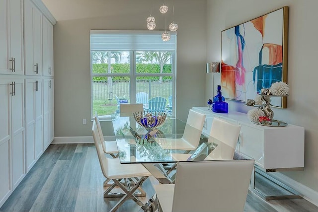 dining area with light wood-type flooring and baseboards