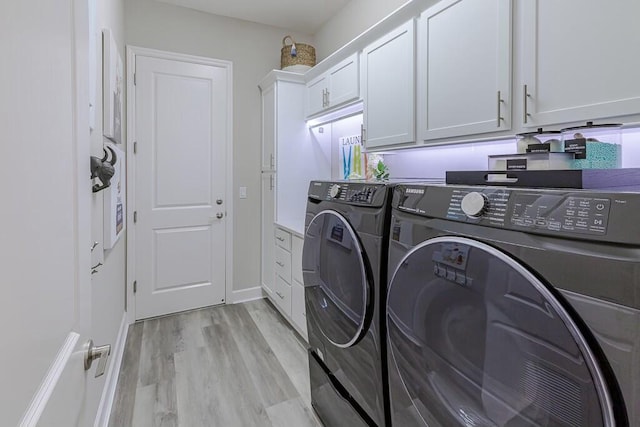 laundry area featuring cabinet space, separate washer and dryer, and light wood-style flooring