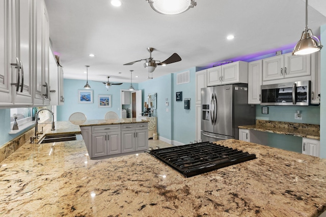 kitchen featuring white cabinetry, sink, decorative light fixtures, and stainless steel appliances