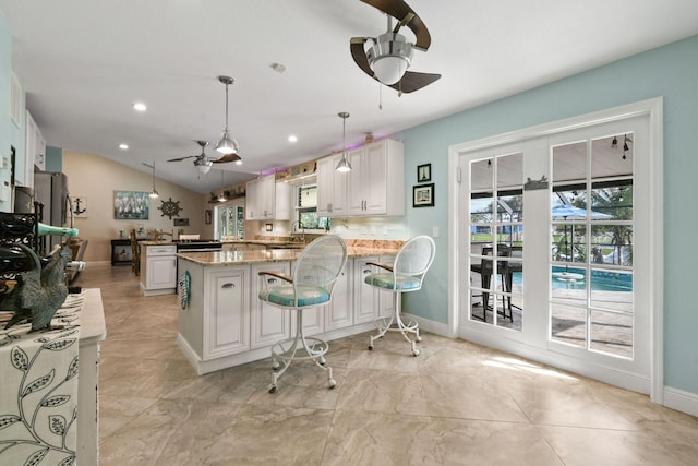 kitchen with ceiling fan, decorative light fixtures, kitchen peninsula, and white cabinets