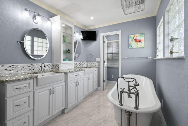 bathroom with vanity, a bathtub, ornamental molding, and a healthy amount of sunlight