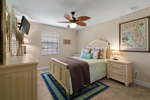 bedroom featuring ceiling fan and a textured ceiling