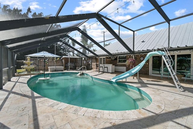 view of pool with a patio, a jacuzzi, a water slide, a lanai, and an outdoor bar