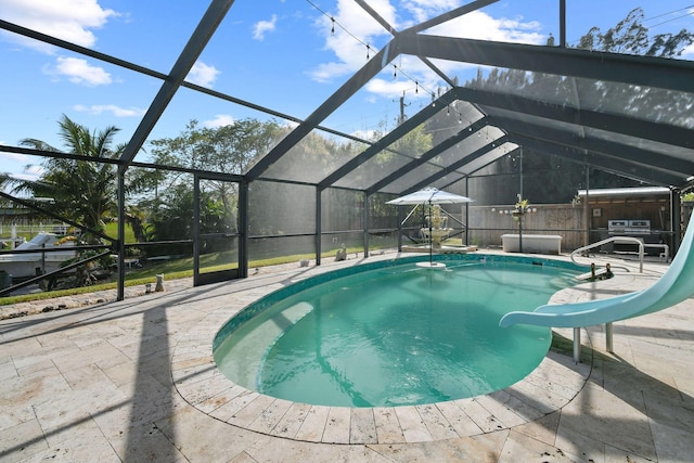 view of swimming pool featuring a hot tub, a water slide, a patio area, and a lanai