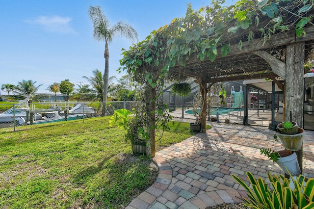 view of yard featuring glass enclosure, a fenced in pool, and a patio area