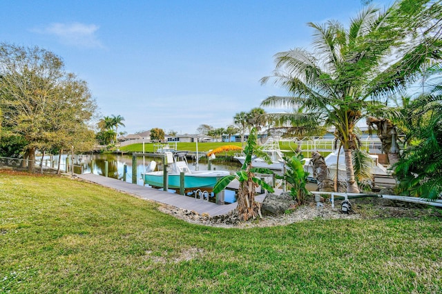 view of dock with a yard and a water view