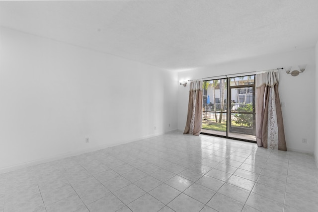 unfurnished room featuring light tile patterned floors and a textured ceiling