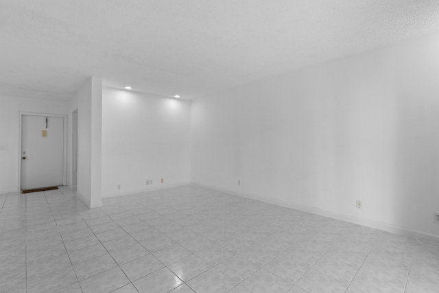 unfurnished room featuring light tile patterned floors and a textured ceiling